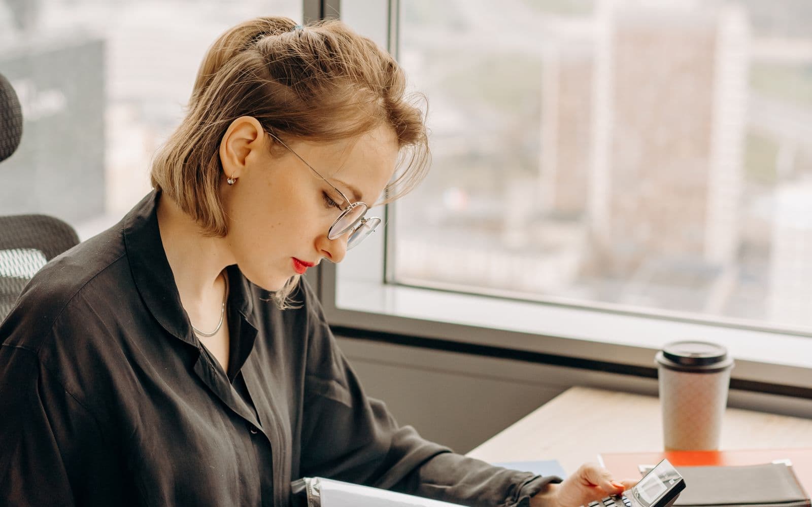 Professional checking documents at a bright office desk