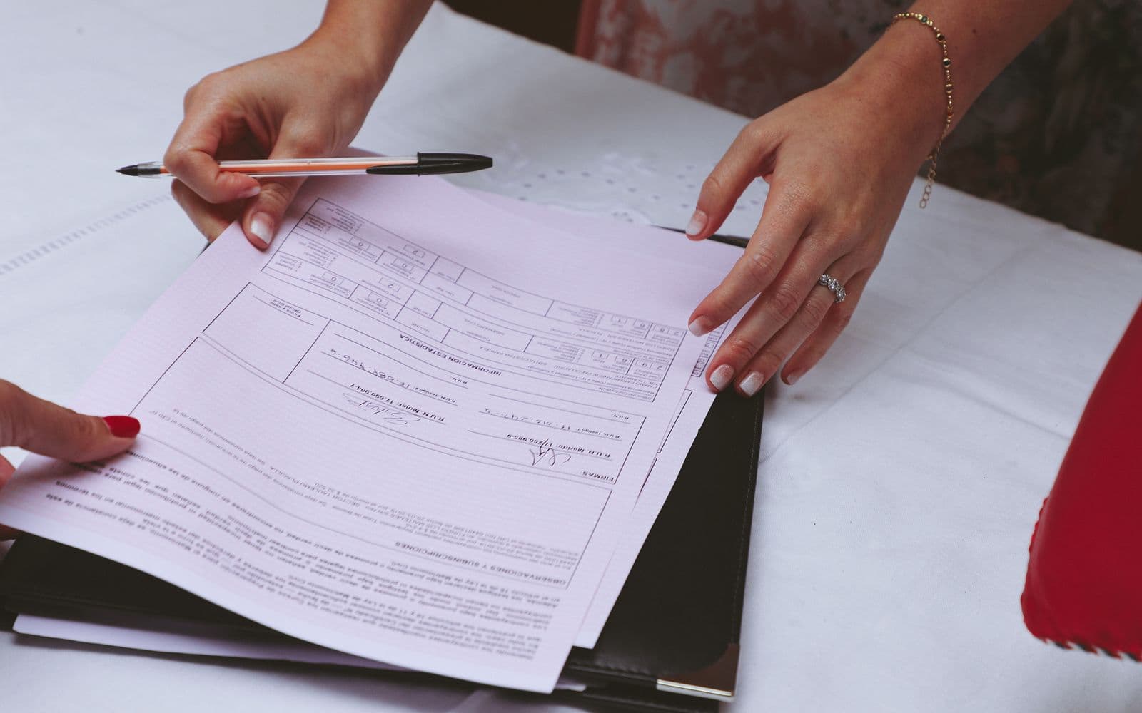 Hands reviewing documents with a pen